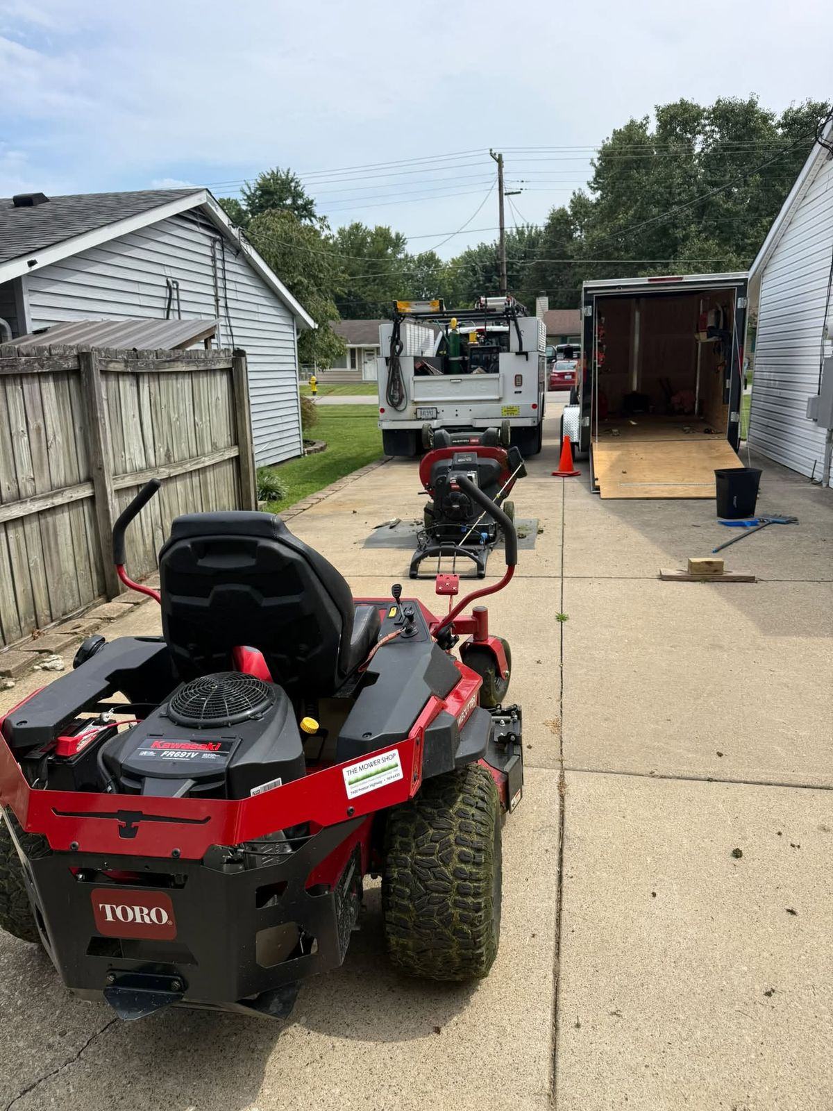 Both Toro mowers staged on a driveway next to the service truck